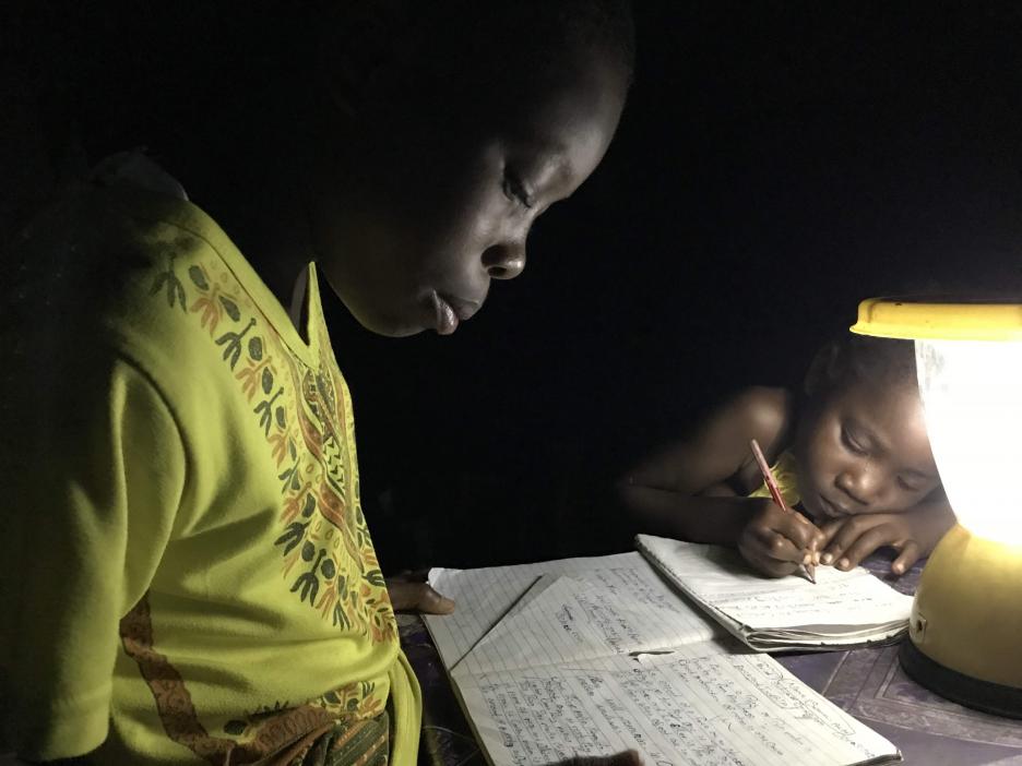 Una lámpara solar ilumina un hogar para que los niños hagan sus deberes después de la puesta del sol.