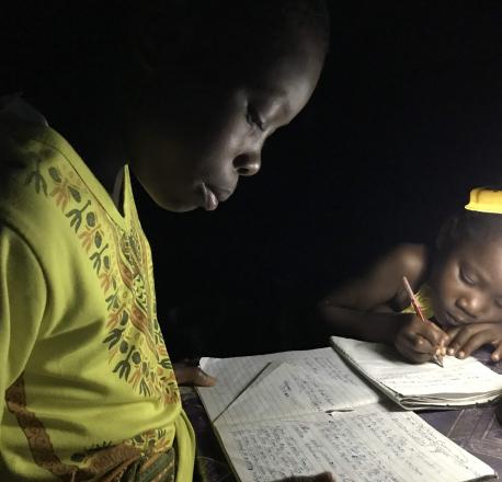 Une lampe solaire éclaire une maison pour que les enfants puissent faire leurs devoirs après le coucher du soleil